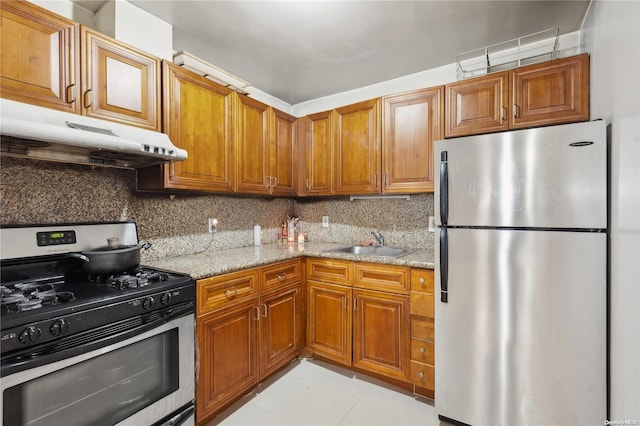 kitchen with light tile patterned flooring, appliances with stainless steel finishes, light stone counters, and sink