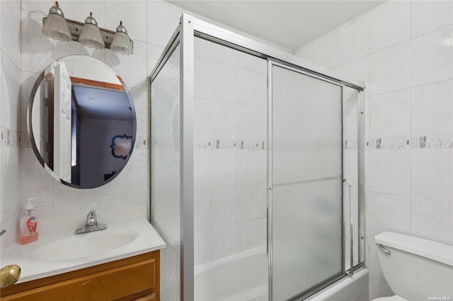 full bathroom featuring combined bath / shower with glass door, tasteful backsplash, vanity, tile walls, and toilet