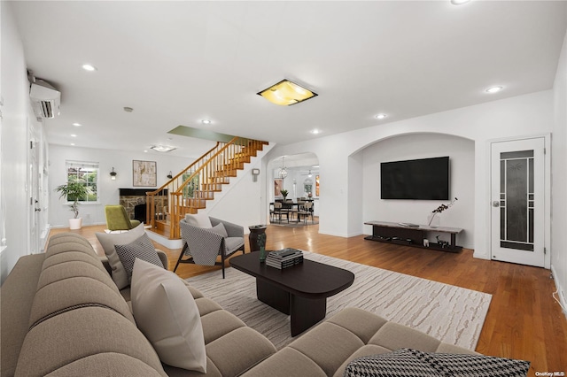 living room with hardwood / wood-style flooring and a wall unit AC