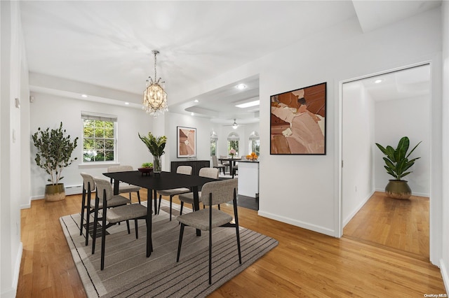 dining area with light wood-type flooring, a baseboard radiator, and a chandelier