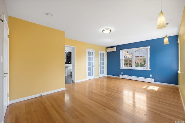 unfurnished living room featuring hardwood / wood-style floors, a baseboard radiator, and a wall unit AC