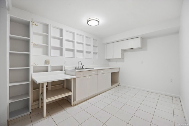 kitchen featuring white cabinetry, sink, and light tile patterned floors