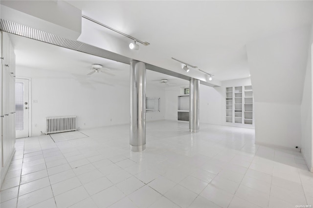 tiled empty room featuring radiator, ceiling fan, built in features, and track lighting