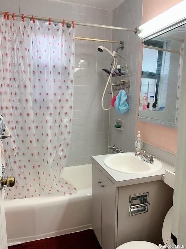 full bathroom featuring vanity, tiled shower / bath combo, and toilet