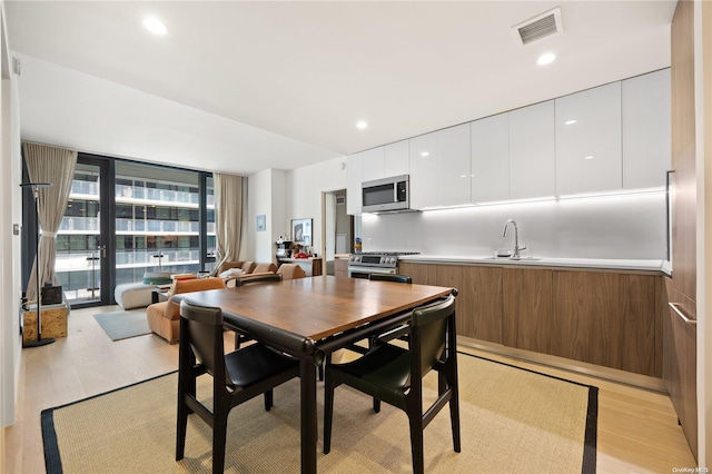 dining space with sink and light hardwood / wood-style floors