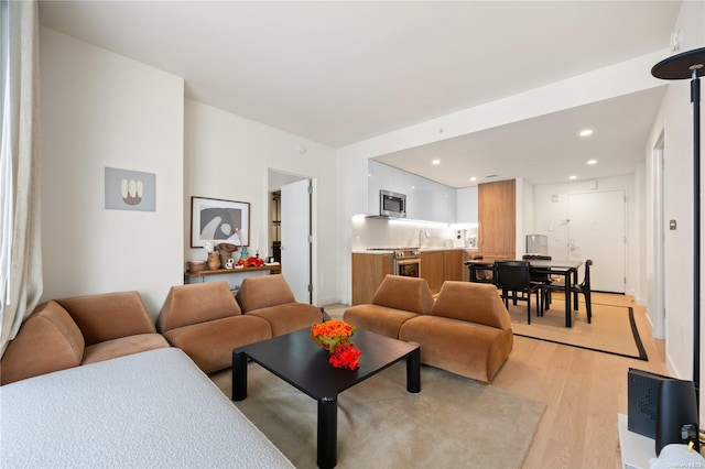 living room with sink and light hardwood / wood-style flooring