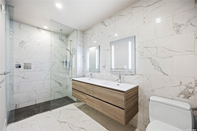 bathroom with tiled shower, vanity, tile walls, and toilet