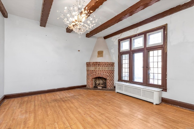 unfurnished living room featuring a fireplace, a chandelier, beamed ceiling, and radiator