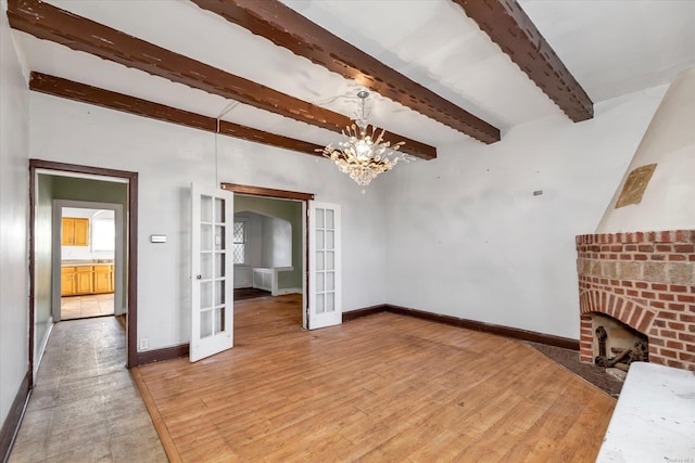 living room featuring a fireplace, french doors, beamed ceiling, and hardwood / wood-style floors