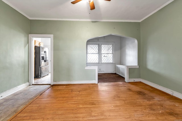 spare room with ornamental molding, light wood-type flooring, and ceiling fan