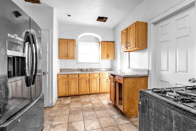 kitchen with black appliances, light tile patterned flooring, and sink