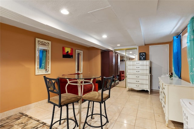 dining area featuring light tile patterned floors and a textured ceiling