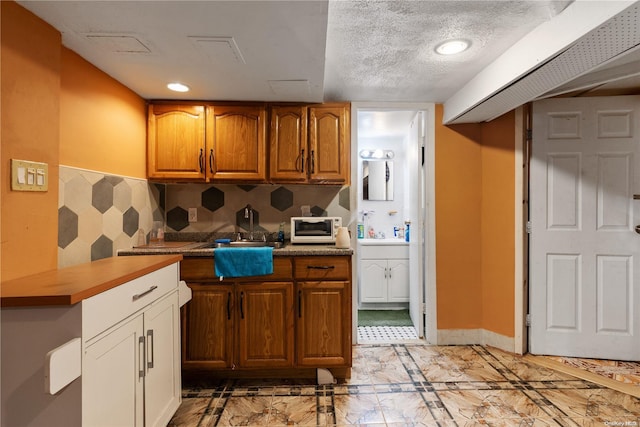 kitchen with wooden counters and a textured ceiling