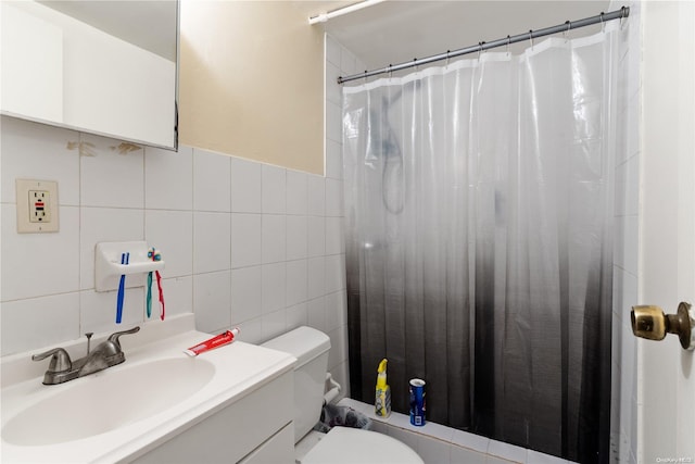 bathroom with walk in shower, vanity, toilet, and tile walls