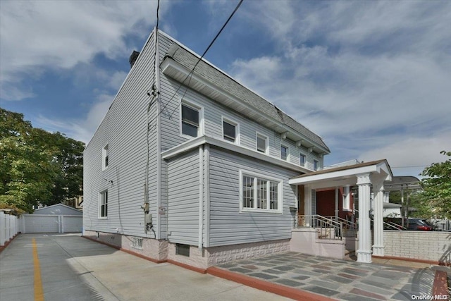 back of property with an outdoor structure and a garage