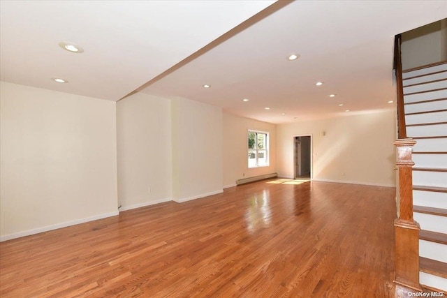 unfurnished living room with light hardwood / wood-style flooring and a baseboard heating unit