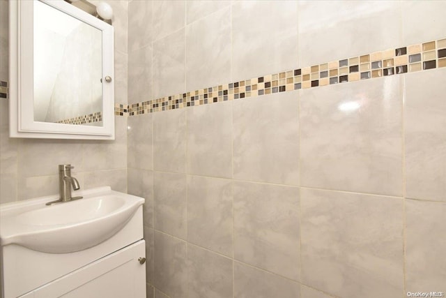 bathroom featuring vanity and tile walls