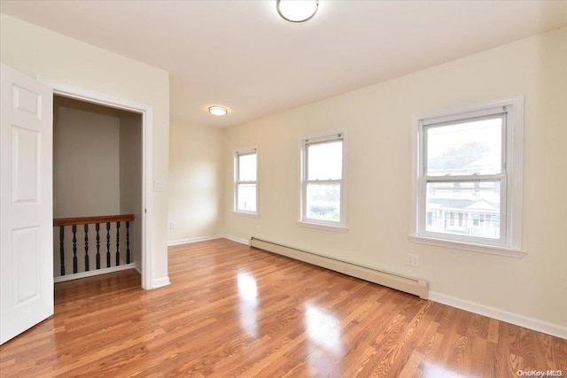 unfurnished room with light wood-type flooring and baseboard heating