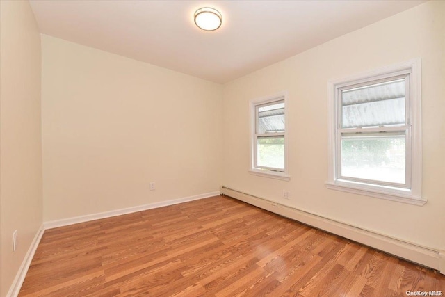 spare room featuring light wood-type flooring and baseboard heating