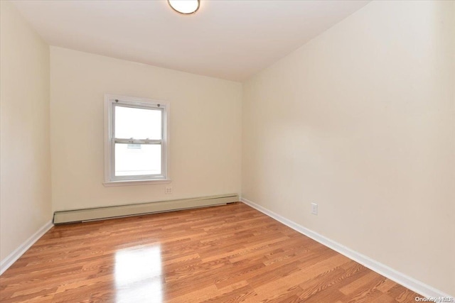 unfurnished room featuring light wood-type flooring and baseboard heating