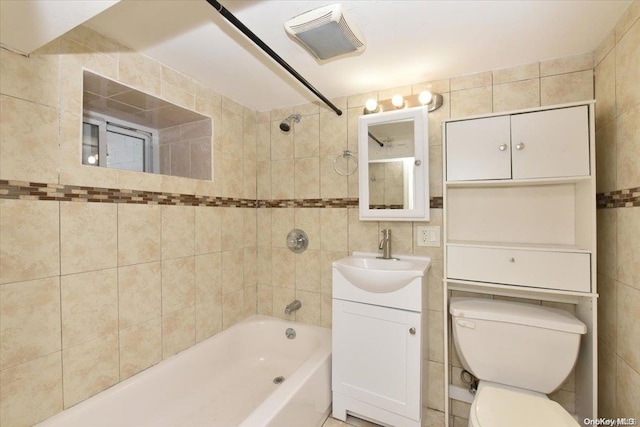 full bathroom featuring vanity, toilet, tile walls, and tiled shower / bath