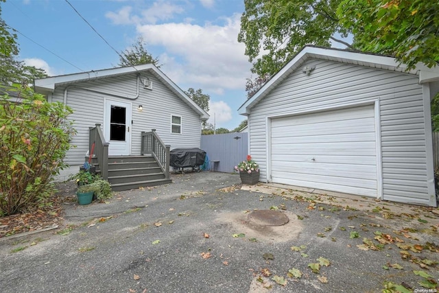 rear view of property featuring an outbuilding and a garage