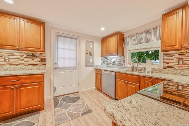 kitchen featuring dishwasher, tasteful backsplash, light hardwood / wood-style floors, and sink