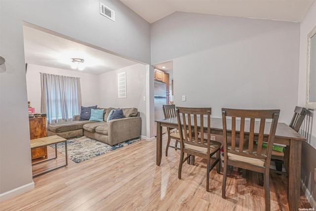 dining room with light hardwood / wood-style floors and lofted ceiling