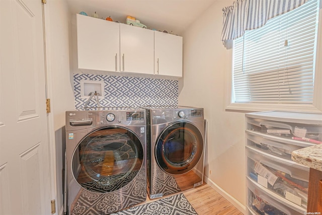 washroom featuring cabinets, independent washer and dryer, and light hardwood / wood-style floors