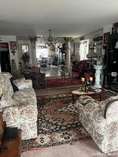 carpeted living room with a chandelier