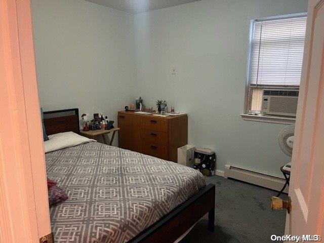 carpeted bedroom with cooling unit and a baseboard radiator