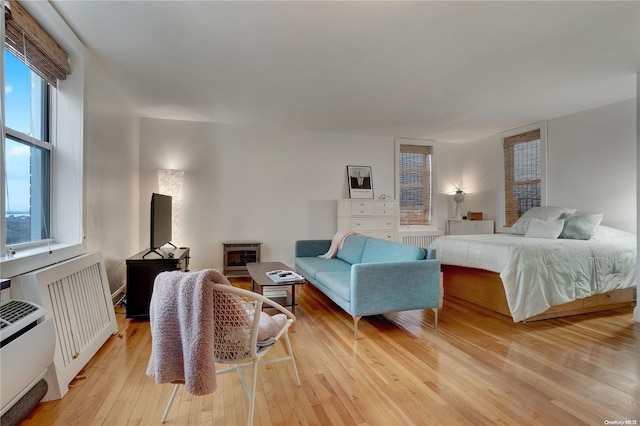 bedroom featuring radiator and light hardwood / wood-style floors