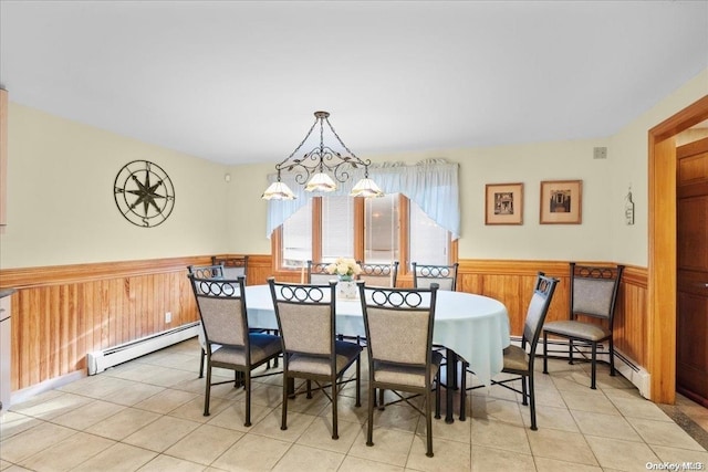 dining room with wooden walls, a notable chandelier, a baseboard heating unit, and light tile patterned flooring