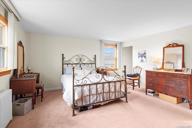 bedroom featuring light carpet and radiator heating unit