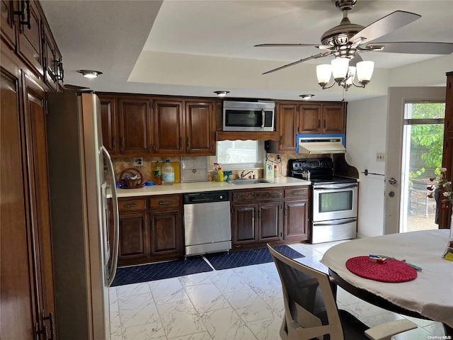 kitchen with decorative backsplash, appliances with stainless steel finishes, ceiling fan, and sink