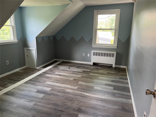 bonus room featuring hardwood / wood-style flooring, radiator heating unit, and vaulted ceiling