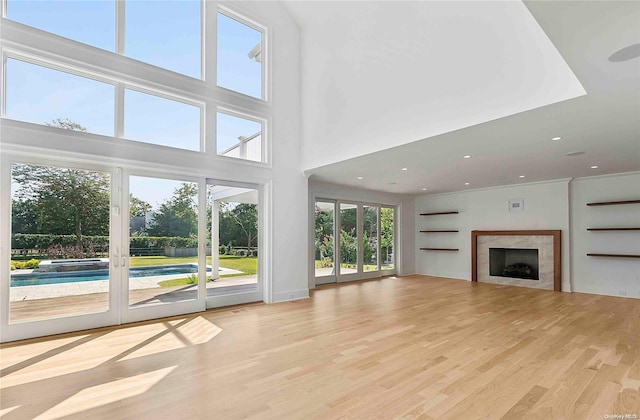 unfurnished living room with light hardwood / wood-style floors and a towering ceiling