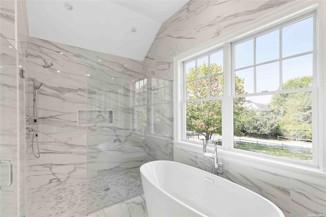 bathroom featuring lofted ceiling, shower with separate bathtub, and tile walls