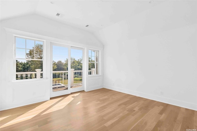 interior space with plenty of natural light, wood-type flooring, and vaulted ceiling