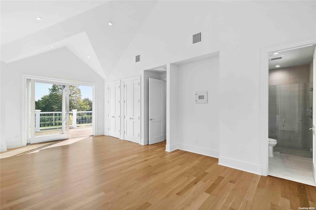 unfurnished bedroom featuring access to exterior, high vaulted ceiling, light hardwood / wood-style floors, and ensuite bath