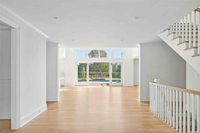 hallway with light hardwood / wood-style flooring and ornamental molding