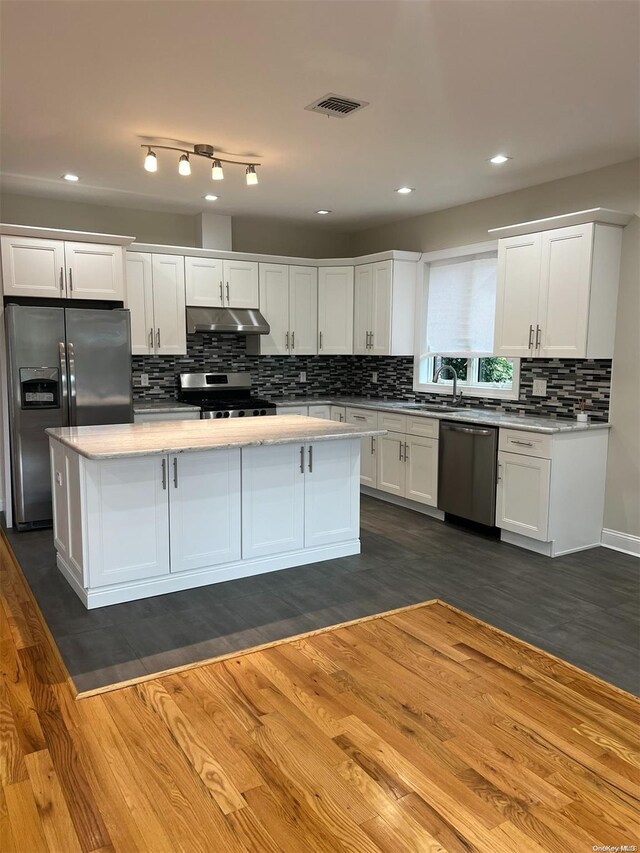 kitchen featuring white cabinets, dark hardwood / wood-style floors, a kitchen island, and stainless steel appliances