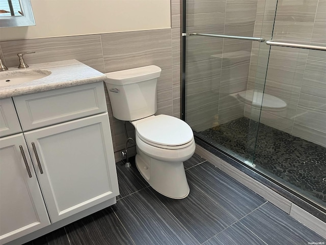 bathroom with walk in shower, vanity, tile patterned floors, and tile walls