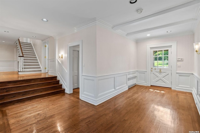 entrance foyer featuring hardwood / wood-style flooring, radiator heating unit, and ornamental molding