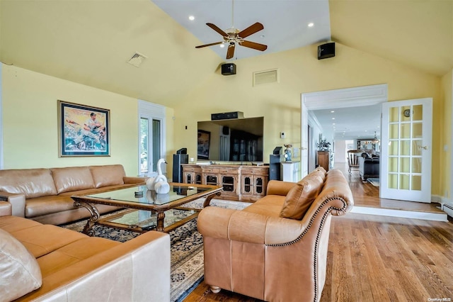 living room with light hardwood / wood-style floors, high vaulted ceiling, and ceiling fan