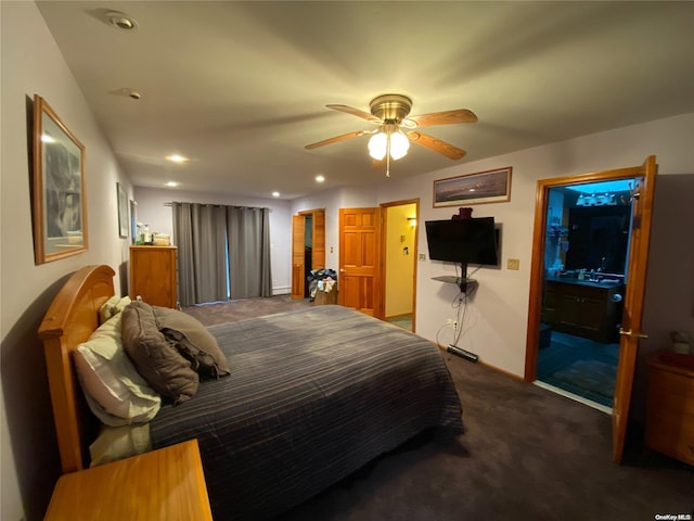 bedroom with ceiling fan, ensuite bathroom, and dark carpet