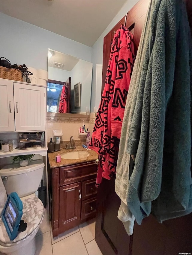 bathroom with tile patterned flooring, vanity, and toilet