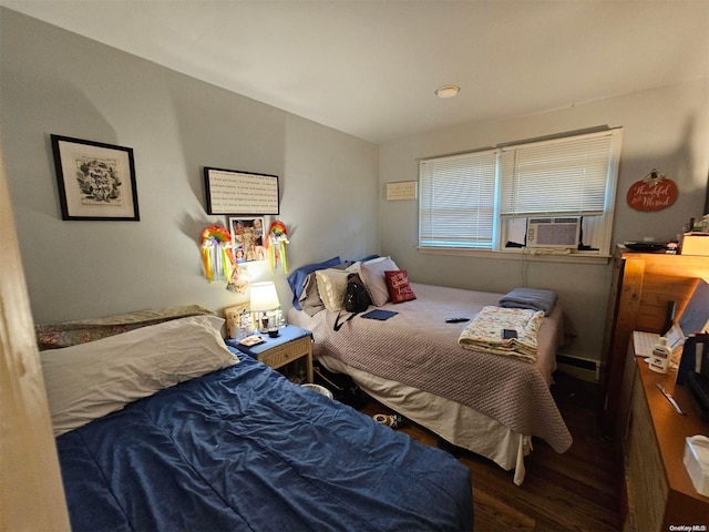 bedroom featuring baseboard heating, dark hardwood / wood-style flooring, and cooling unit