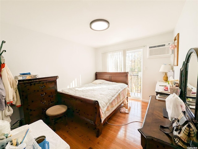 bedroom featuring light hardwood / wood-style flooring and a wall mounted AC