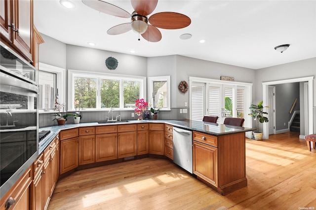 kitchen featuring kitchen peninsula, stainless steel appliances, plenty of natural light, and sink